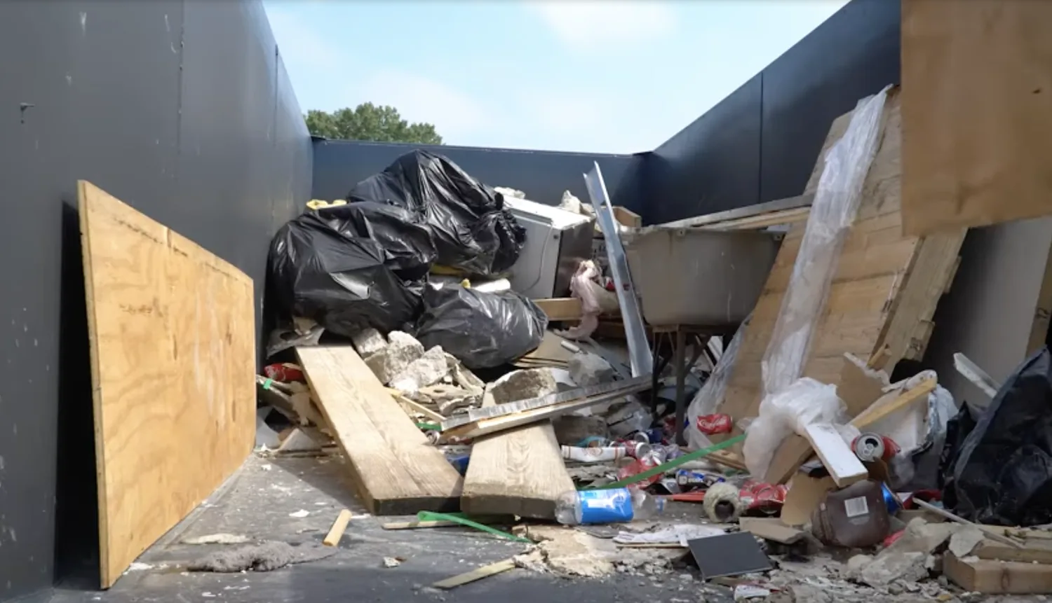 Inside a loaded roll-off dumpster full of mixed demolition and household debris