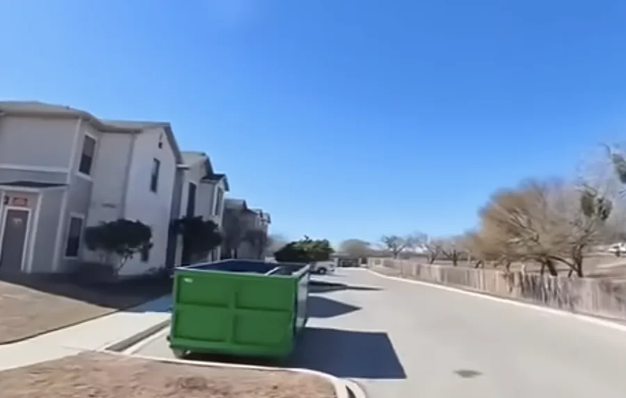 A front-load dumpster serving a multi-family apartment property
