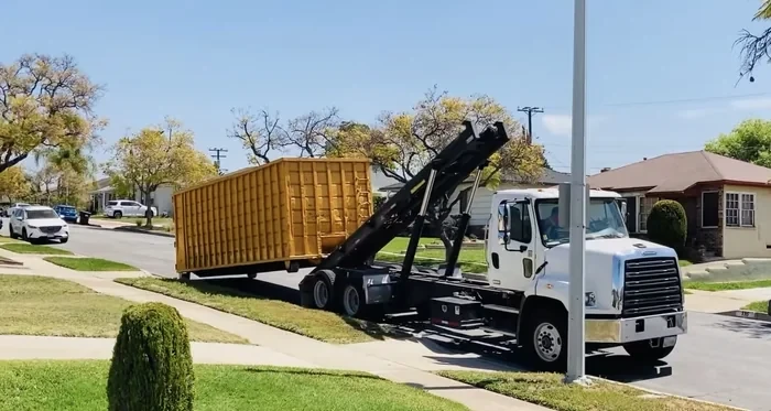 A roll-off dumpster at the curb on a residential street, the placement that needs a city permit.